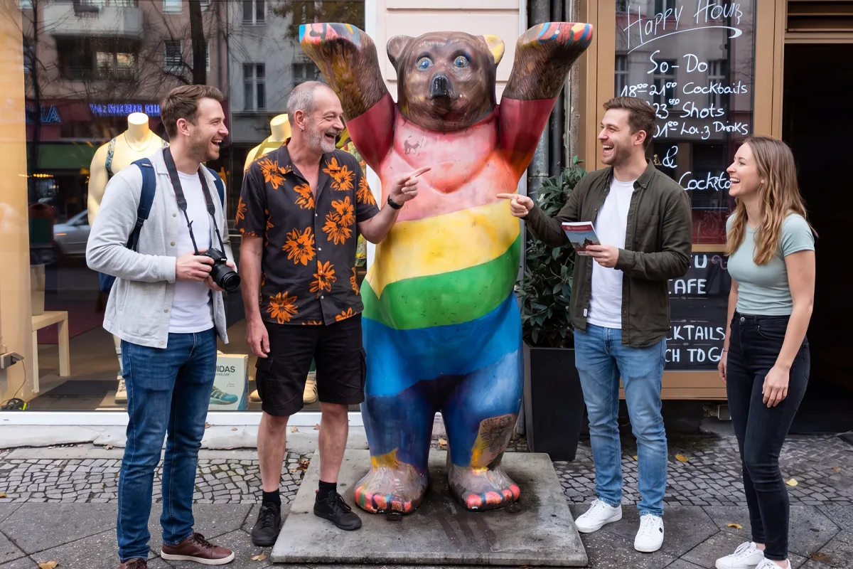 Tour group posing by a Berlin Bear sculpture in rainbow colours