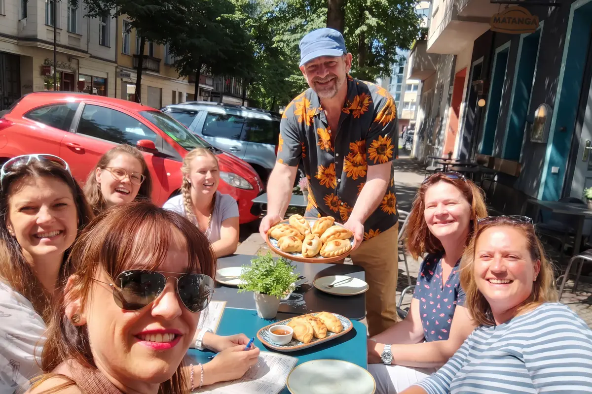 Host, Klaus, serving empanadas to a group of tour guests on the Falkensteinstraße, Kreuzberg